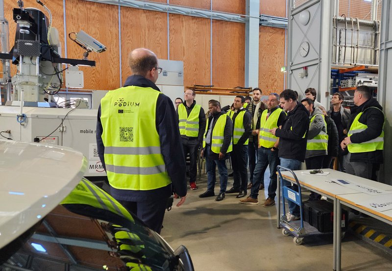 The project partners inspect the mobile infrastructure sensors and the test vehicles in the hall of the Institute for Measurement, Control and Microtechnology at Ulm University